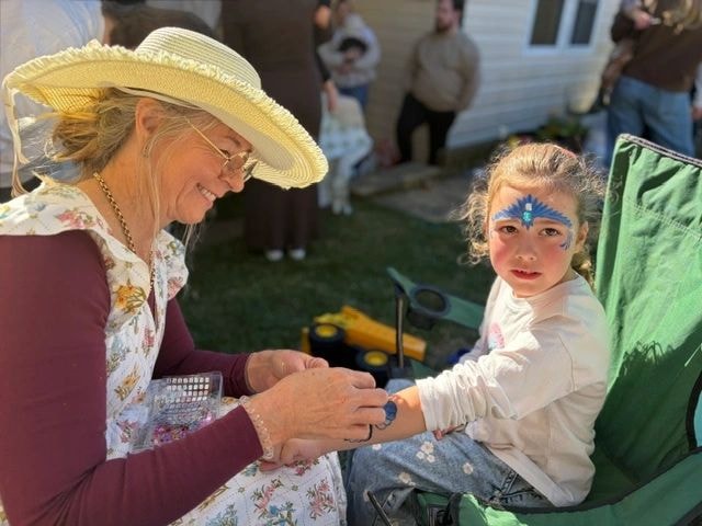Nanna Nanna applying face paint to a child