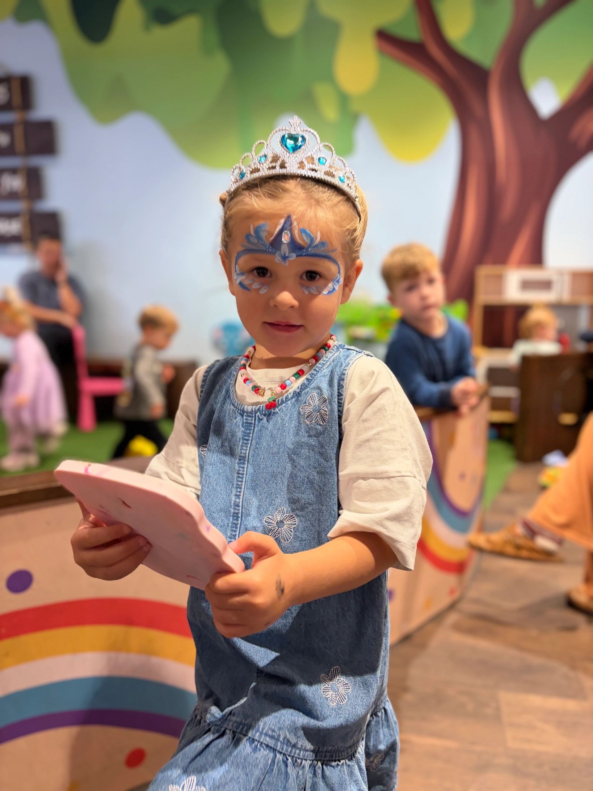 Child wearing tiara and face paint