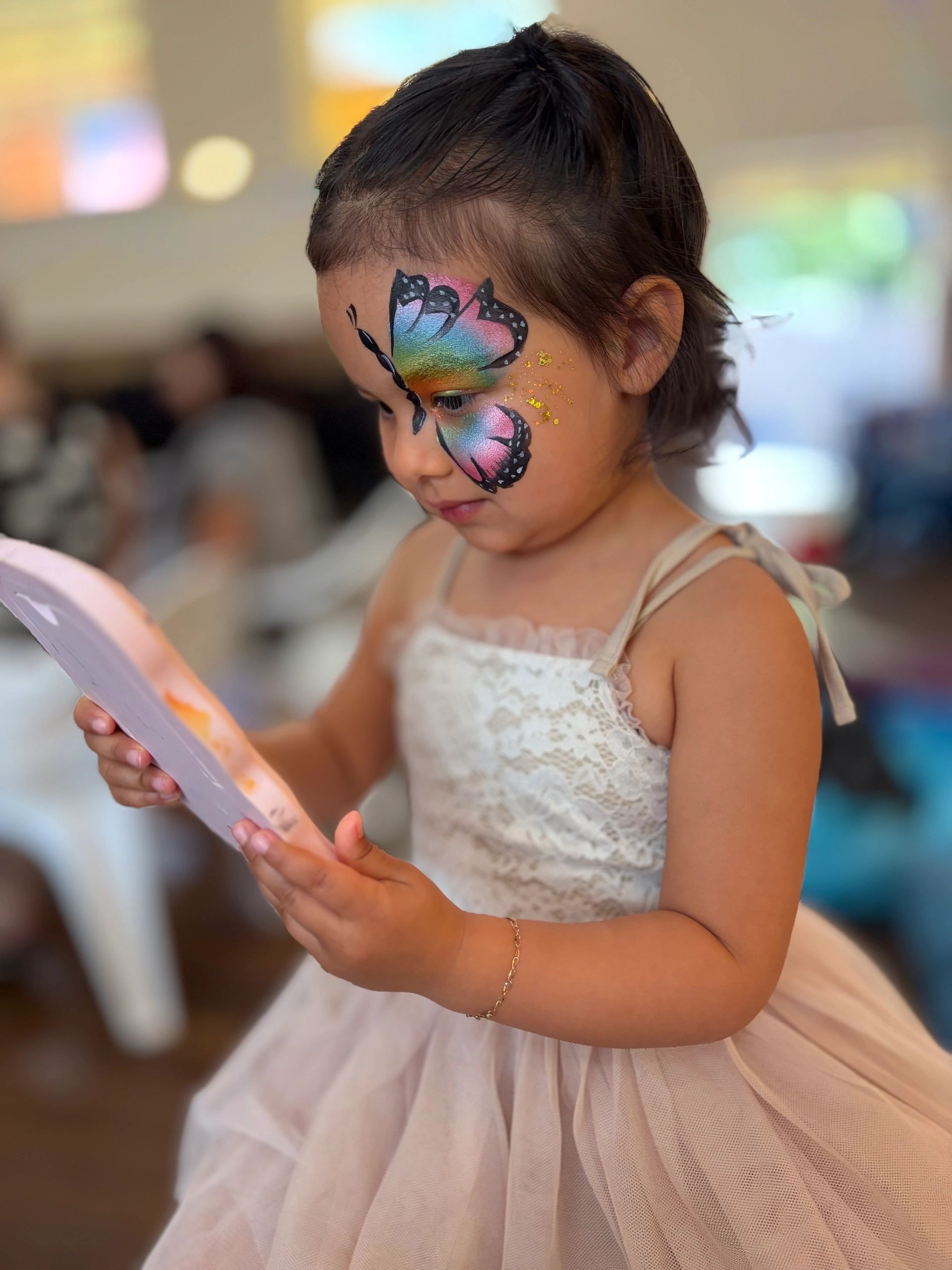 Child with rainbow butterfly face paint