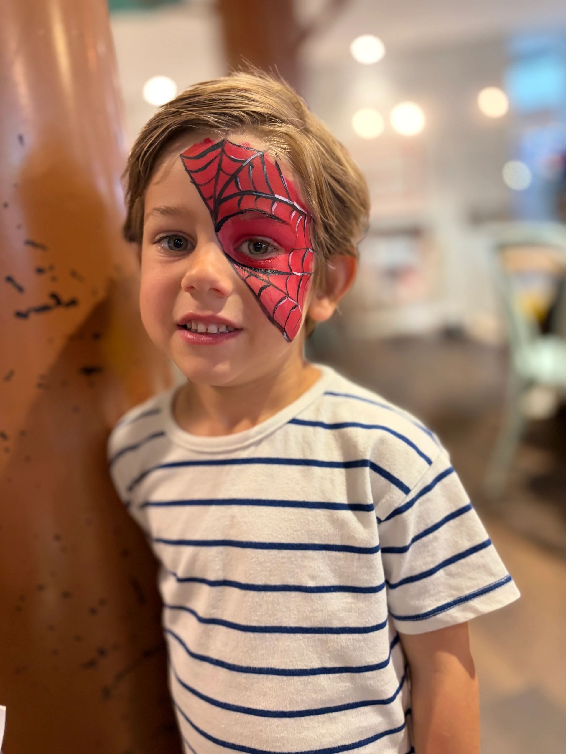Child with spider web face paint